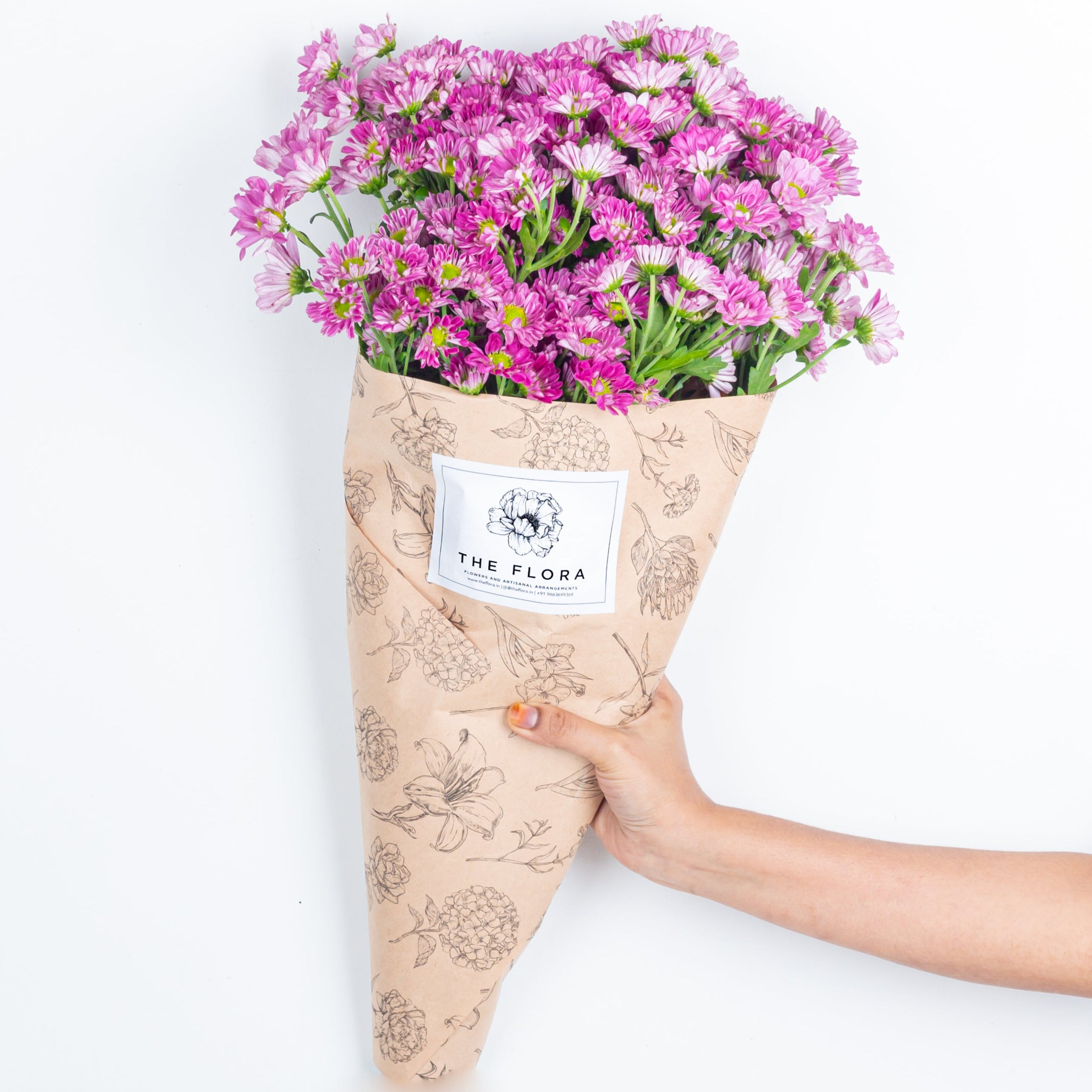 Bouquet of pink flowers Santini Chrysanthemums wrapped in beige paper with 'The Flora' label . Online cut flowers n sustainable packaging from www.theflora.in