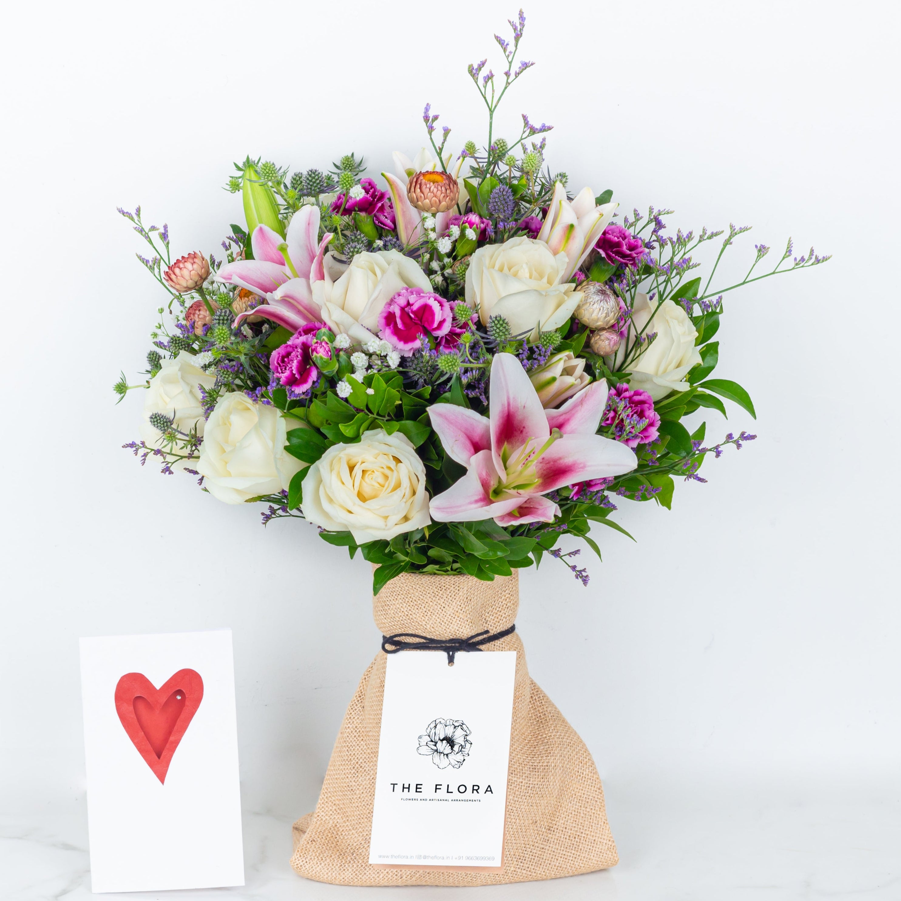 Bouquet of flowers in a paper bag called Soulful Strings. An artisanal bouquet of Eryngium, Roses, Oriental Lilies Helichrysum, Spray Carnations. and Limonium. Online artisanal bouquets with same day delivery at www.theflora.in