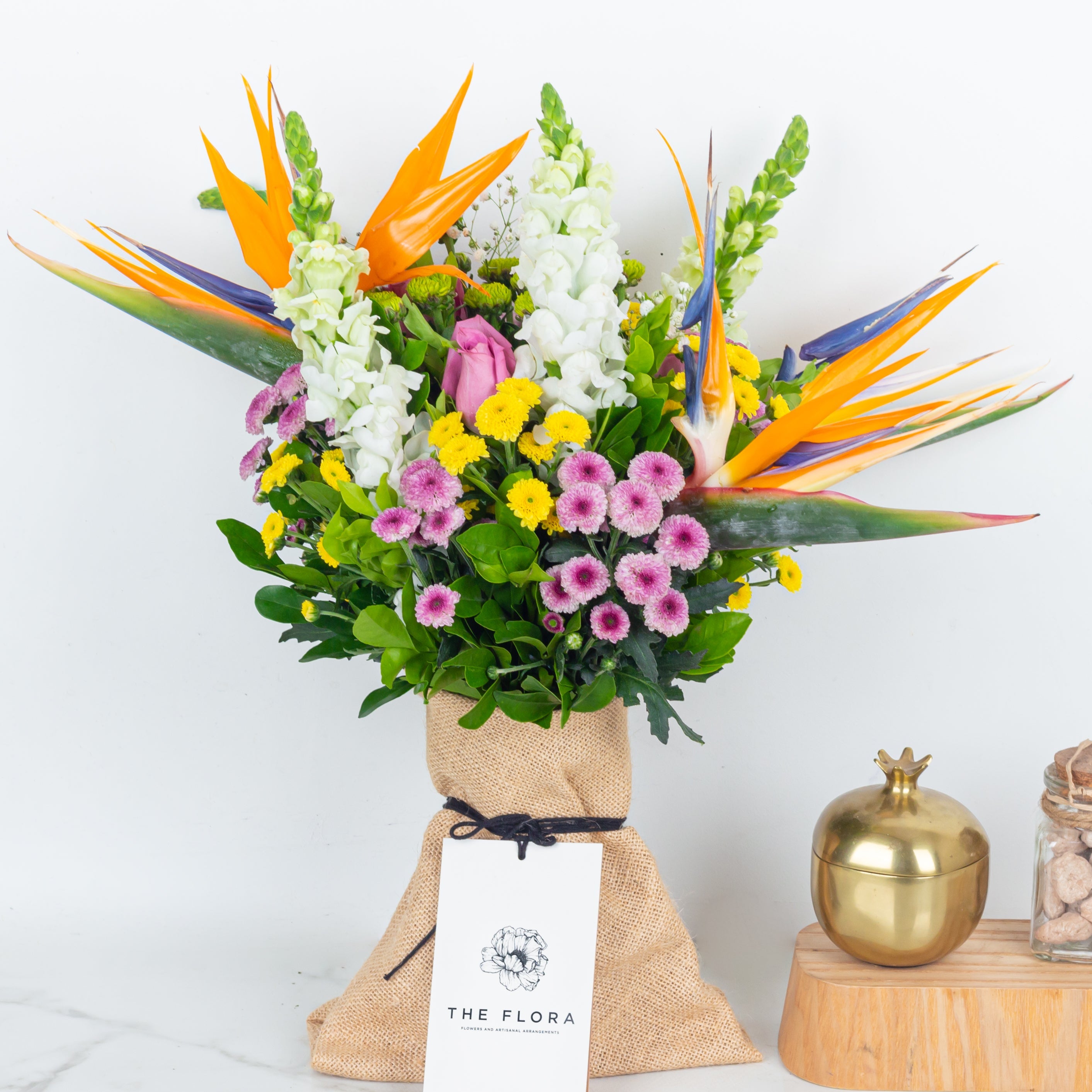 An artisanal bouquet called with all my heart curated with Birds of Paradise, Button Chrysanthemums and roses. Online artisanal bouquets with same day delivery in sustainable packaging at www.theflora.in
