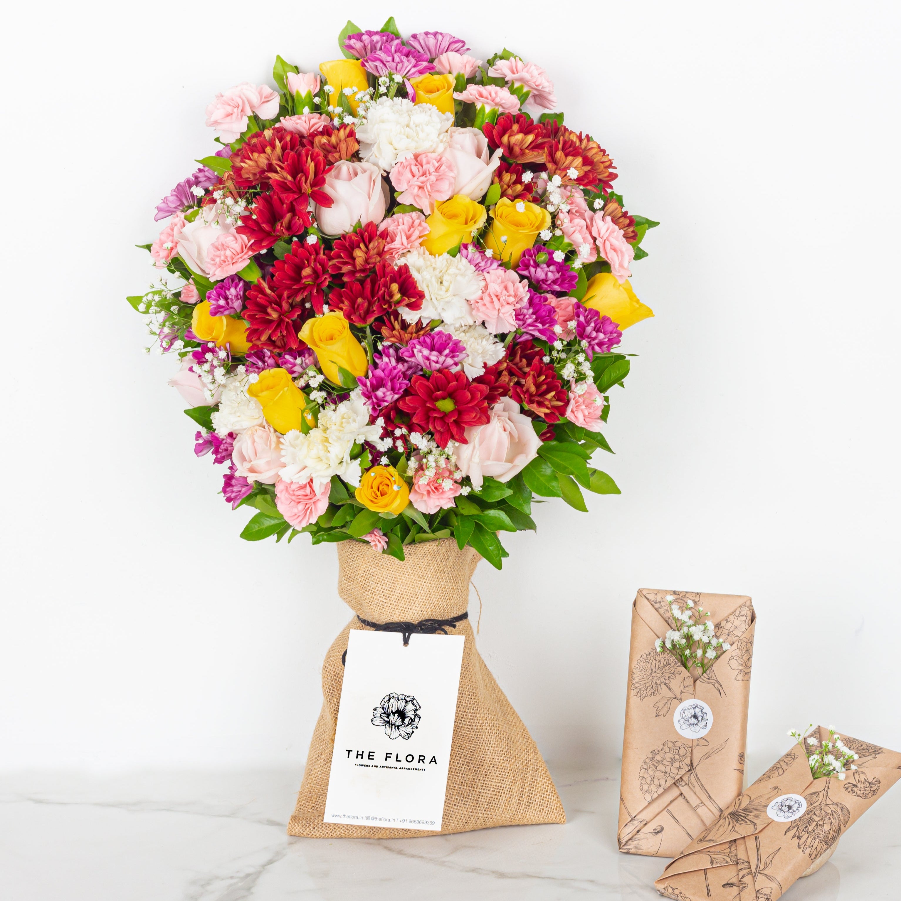 Colorful bouquet of flowers with 'The Flora' label on a white background