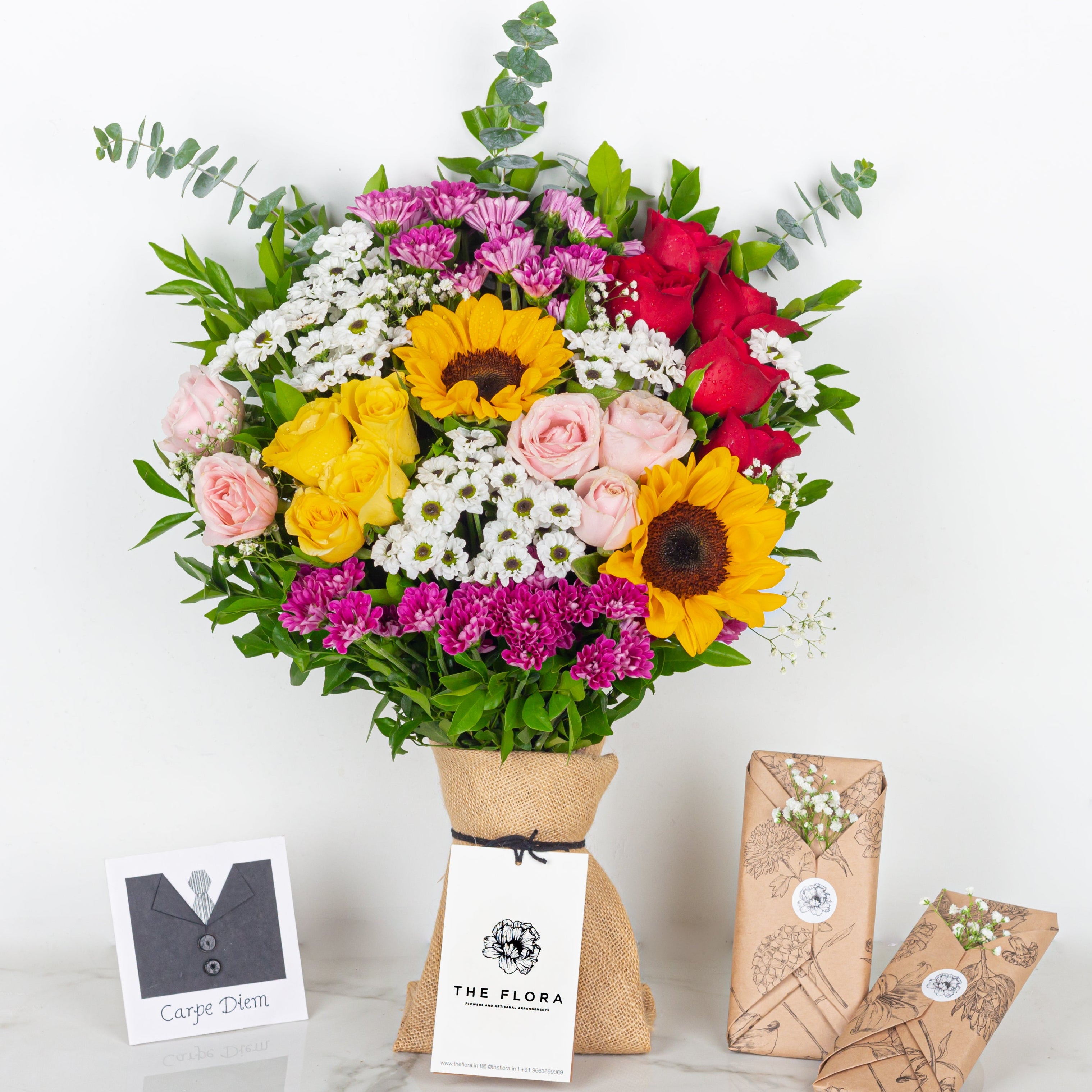 Colorful bouquet of flowers with packaging and cards on a white background