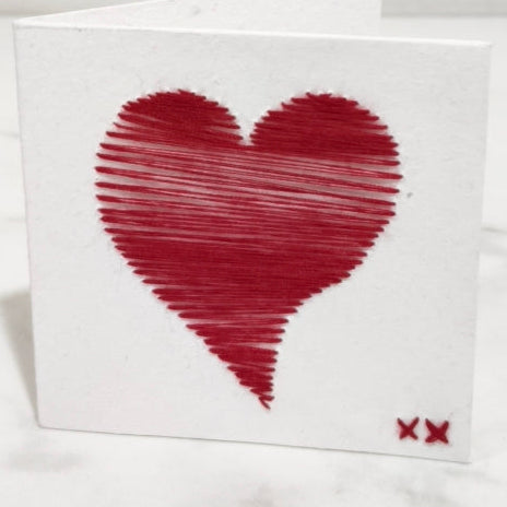 Card with a red heart design on a white fabric background